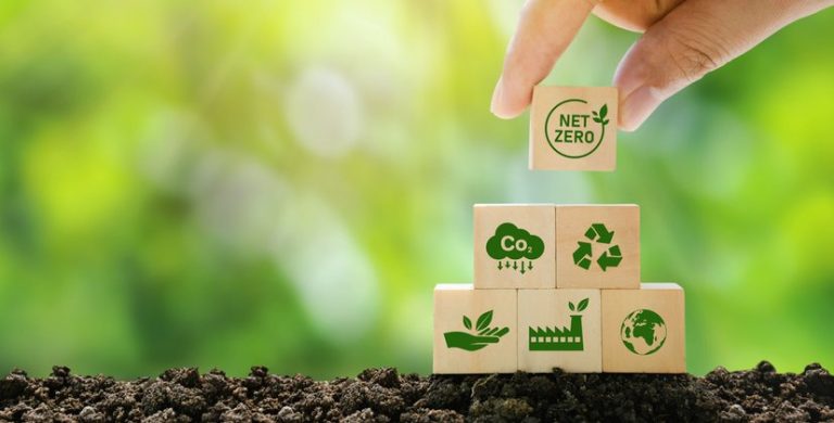 Net Zero and Carbon Neutral Concepts Net Zero Emissions Goals A climate-neutral long-term strategy Ready to put wooden blocks by hand with green net center icon and green icon on gray background